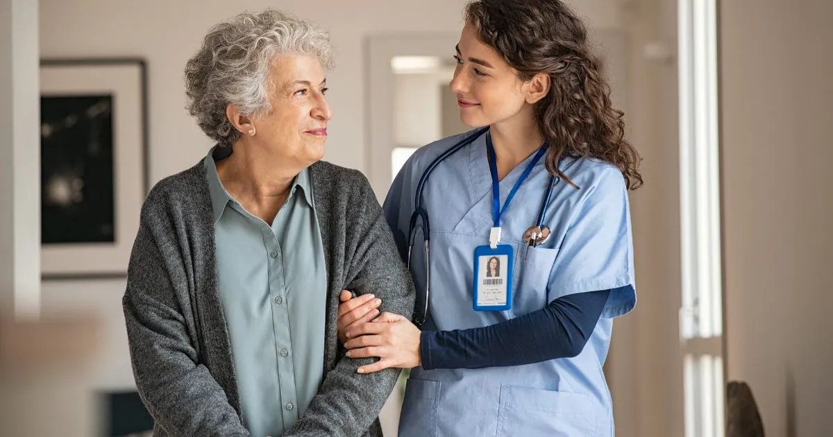 Elderly woman walking the nursing home with nurse